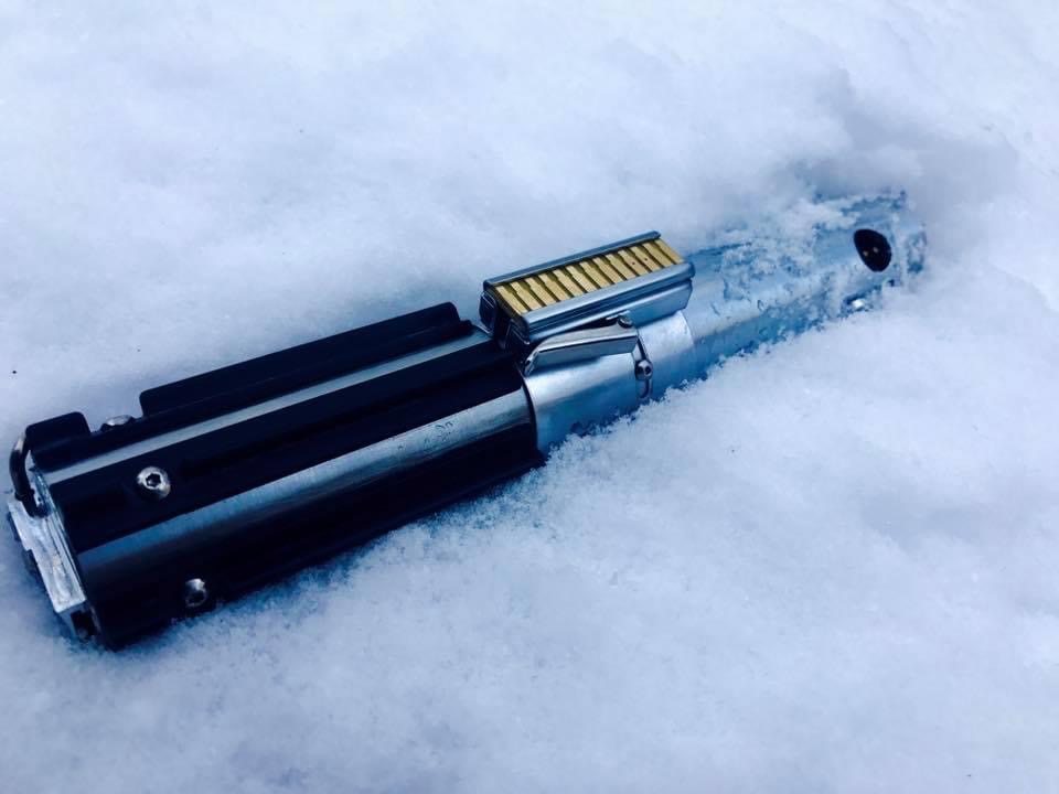 DIY lightsaber, reminiscent of Luke Skywalker's lightsaber from Empire Strikes Back, laying sideways amid a snowy landscape.